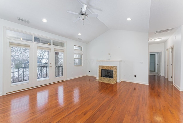 unfurnished living room with ceiling fan, plenty of natural light, wood-type flooring, and vaulted ceiling