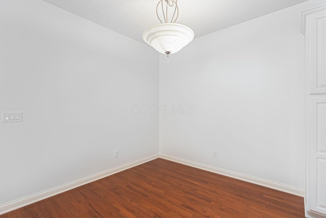 spare room featuring dark wood-type flooring