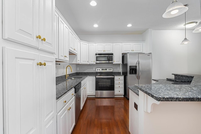 kitchen featuring white cabinetry, sink, hanging light fixtures, and appliances with stainless steel finishes