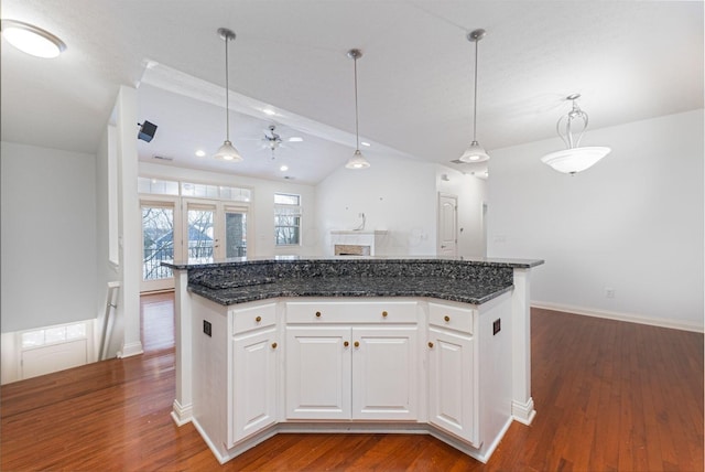 kitchen with ceiling fan, lofted ceiling with beams, decorative light fixtures, white cabinets, and a center island