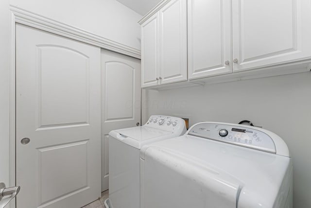 laundry room with washer and clothes dryer and cabinets