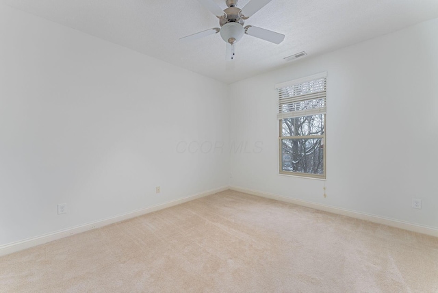 empty room featuring light carpet, ceiling fan, and a textured ceiling