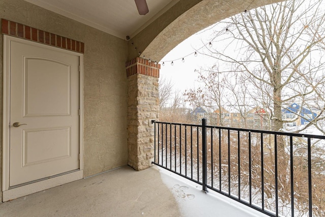 snow covered back of property with ceiling fan