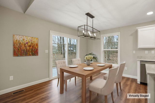 dining space with dark hardwood / wood-style floors and a chandelier