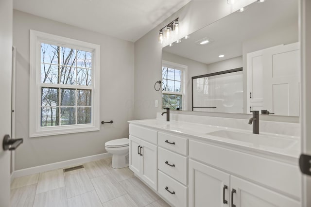 bathroom featuring vanity, toilet, and an enclosed shower