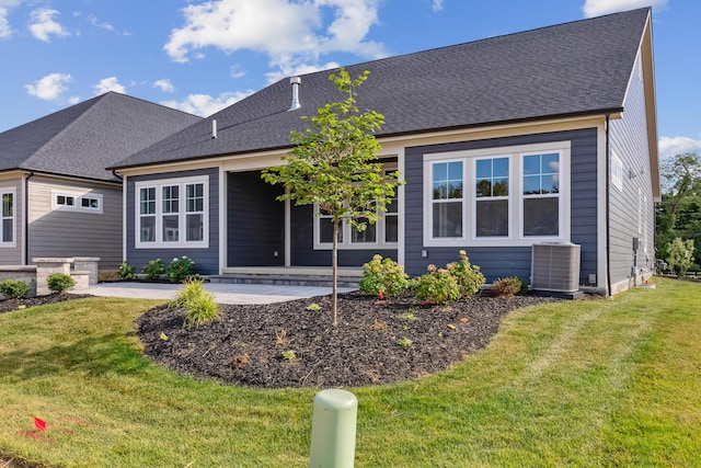 view of front of home with central air condition unit and a front yard