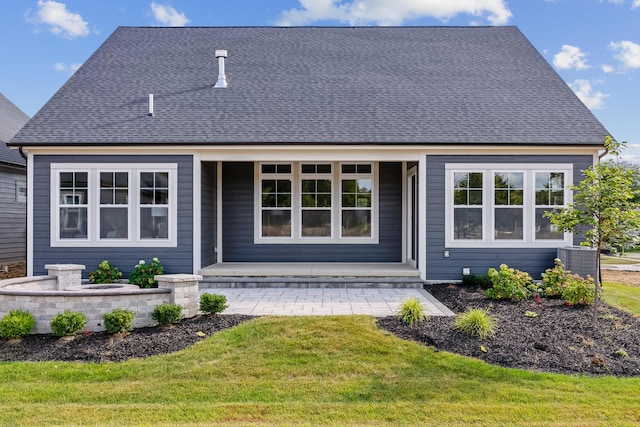 rear view of property featuring a yard and central AC