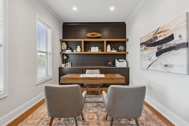 office space with wood-type flooring and crown molding