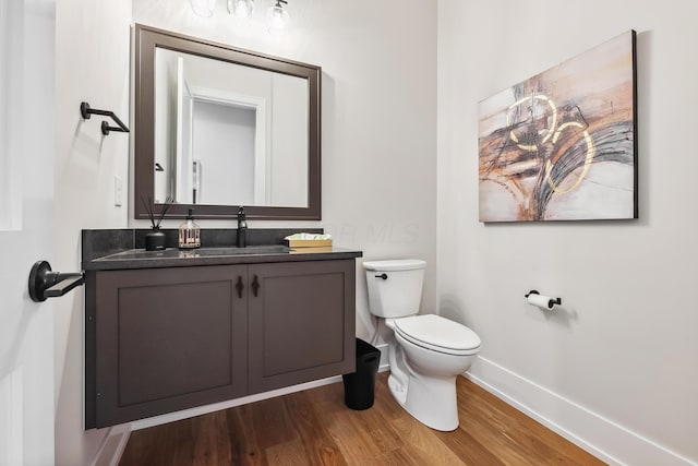 bathroom with vanity, toilet, and wood-type flooring