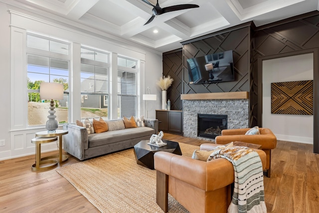 living room with ceiling fan, coffered ceiling, beamed ceiling, light hardwood / wood-style floors, and a fireplace