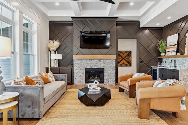 living room featuring beam ceiling, a wealth of natural light, a fireplace, and coffered ceiling