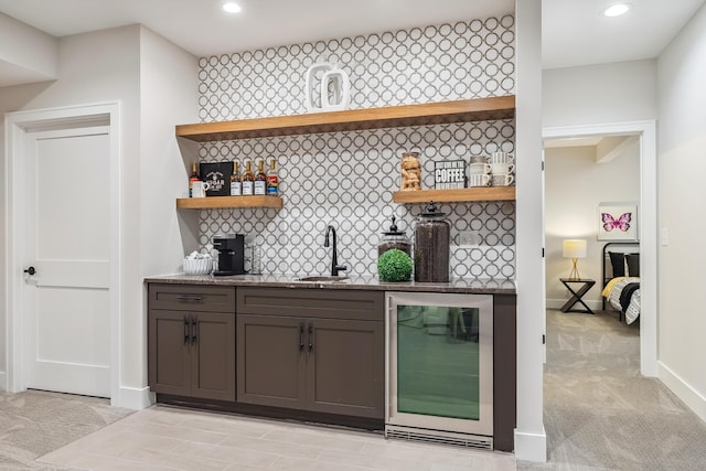 bar featuring backsplash, light carpet, sink, and beverage cooler