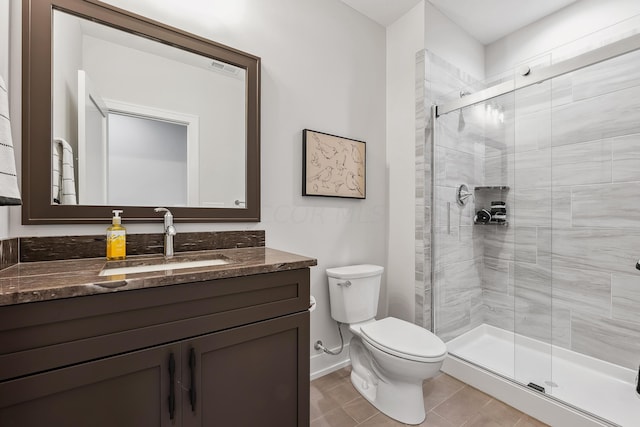 bathroom with tile patterned floors, vanity, toilet, and a shower with door