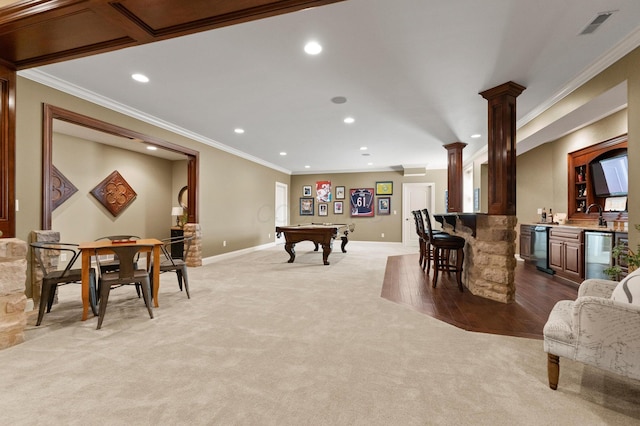 game room featuring light carpet, crown molding, ornate columns, and indoor bar