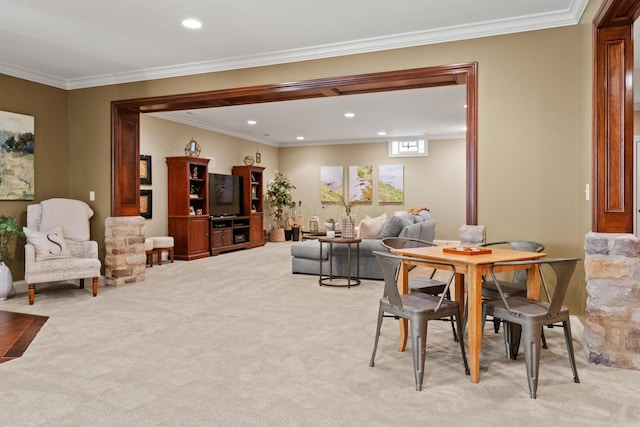 dining space with ornamental molding and light colored carpet