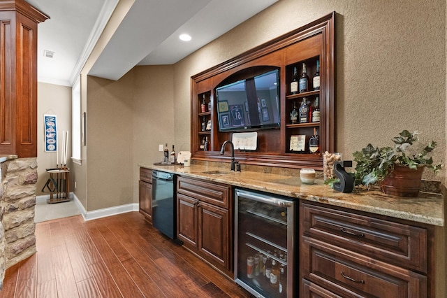 bar featuring dark wood-type flooring, sink, ornamental molding, beverage cooler, and light stone countertops