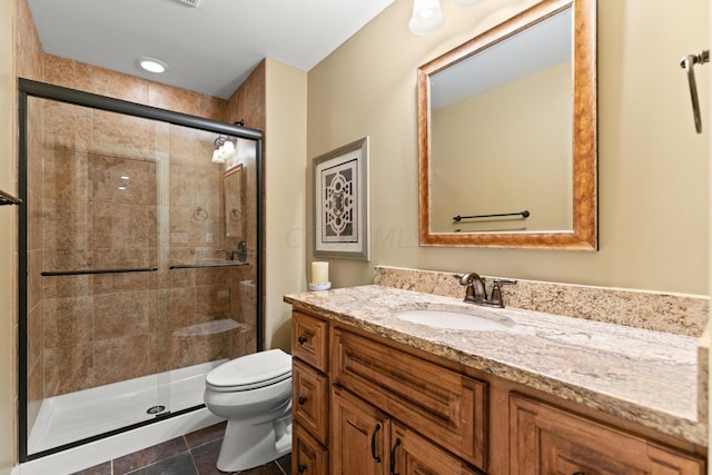 bathroom with vanity, tile patterned flooring, toilet, and walk in shower