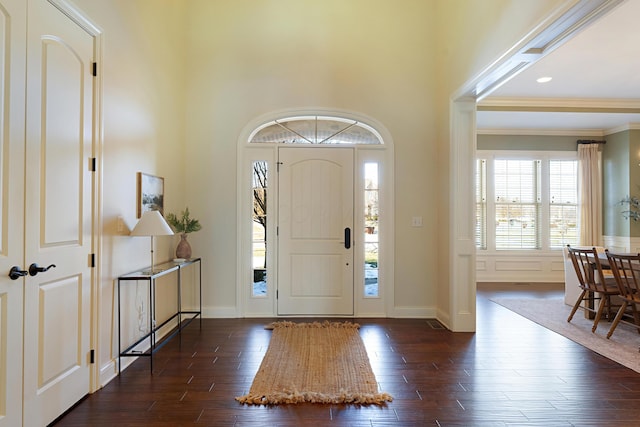 foyer with dark hardwood / wood-style flooring, crown molding, and a high ceiling