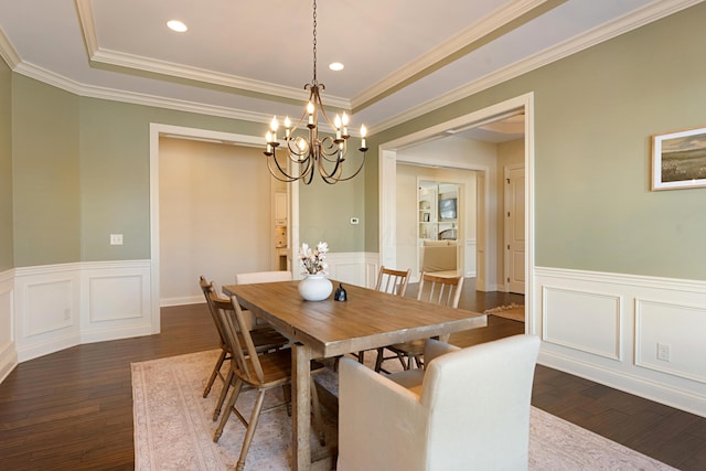 dining space with ornamental molding, dark hardwood / wood-style floors, a notable chandelier, and a tray ceiling