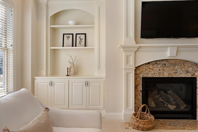 interior space featuring a high end fireplace and built in shelves