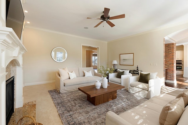 carpeted living room featuring ornamental molding and ceiling fan