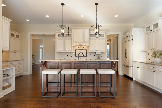 kitchen featuring pendant lighting, dark wood-type flooring, and a kitchen island with sink