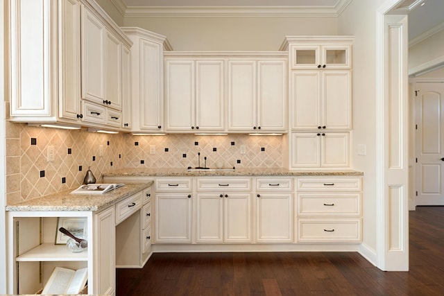 kitchen with ornamental molding, light stone countertops, dark wood-type flooring, and decorative backsplash