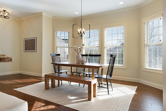 dining room featuring an inviting chandelier, dark hardwood / wood-style flooring, and ornamental molding