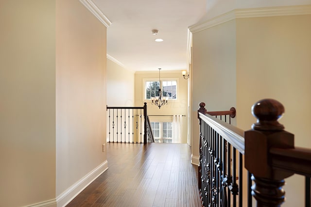 corridor featuring crown molding, dark hardwood / wood-style flooring, and a notable chandelier