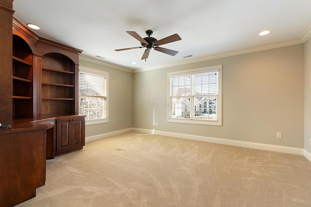 carpeted spare room featuring crown molding, a healthy amount of sunlight, and ceiling fan