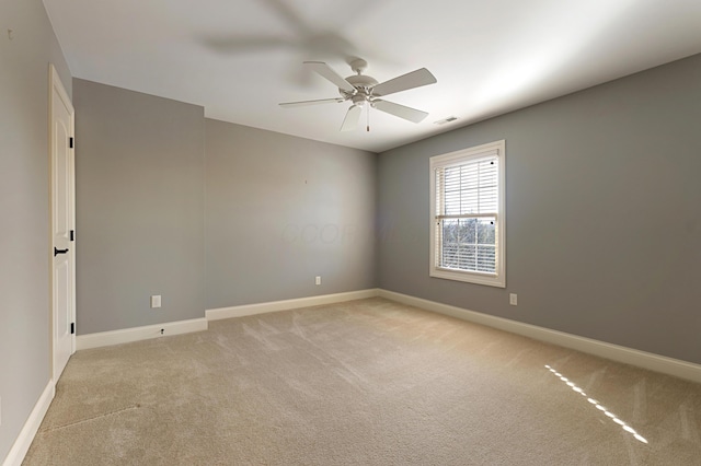 spare room featuring ceiling fan and light colored carpet