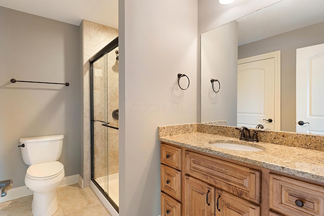 bathroom featuring vanity, tile patterned flooring, toilet, and walk in shower