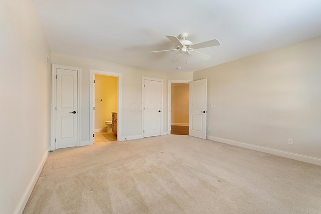 unfurnished bedroom with ceiling fan, light carpet, and ensuite bath