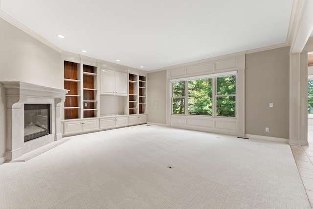 unfurnished living room with a premium fireplace, light colored carpet, and ornamental molding