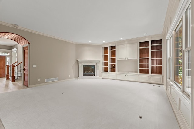 unfurnished living room with light colored carpet and ornamental molding