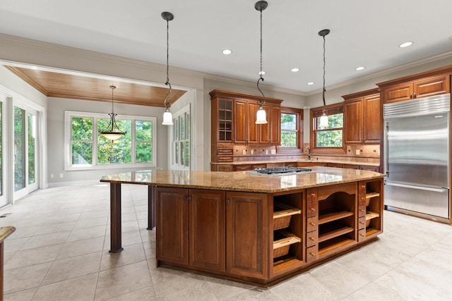 kitchen featuring decorative backsplash, light stone countertops, stainless steel appliances, crown molding, and a kitchen island