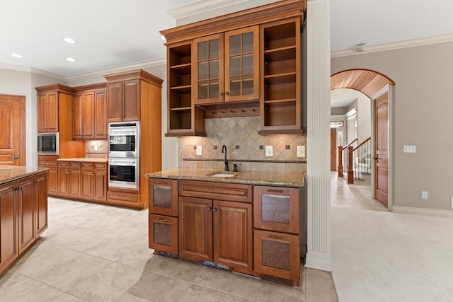 kitchen featuring light tile patterned floors, ornamental molding, and sink