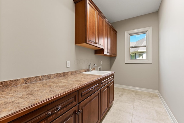 laundry area featuring cabinets, light tile patterned floors, sink, and hookup for a washing machine