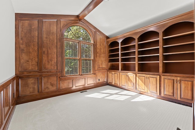 unfurnished room featuring lofted ceiling with beams and light colored carpet