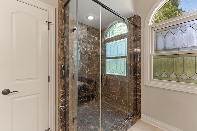 bathroom featuring tile patterned flooring, walk in shower, and a textured ceiling