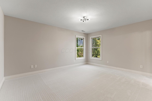 carpeted spare room featuring a textured ceiling