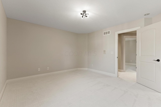 carpeted spare room featuring a textured ceiling