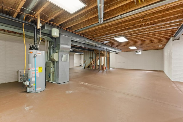 basement featuring brick wall, heating unit, and water heater