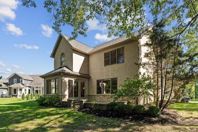 back of property featuring a lawn and a sunroom