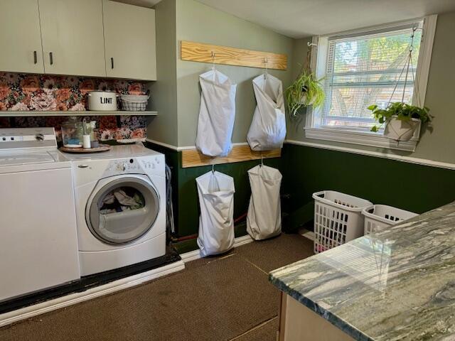 clothes washing area with washing machine and clothes dryer and cabinets