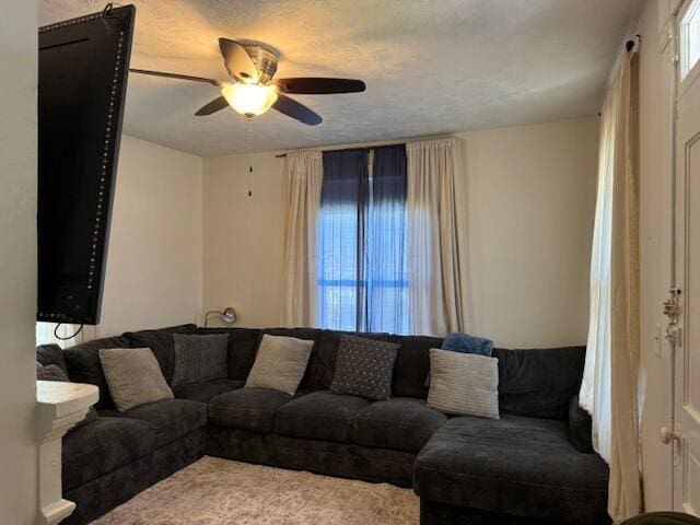 living room with ceiling fan and a textured ceiling