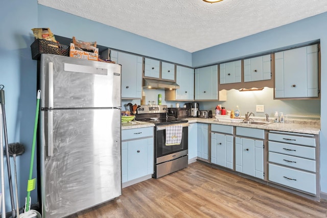 kitchen with sink, stainless steel appliances, a textured ceiling, exhaust hood, and hardwood / wood-style flooring