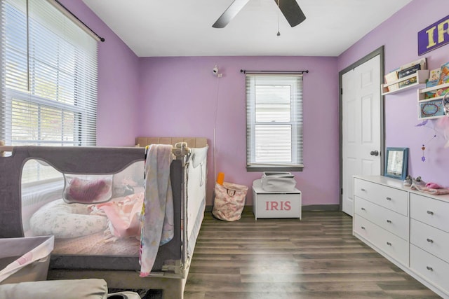 bedroom featuring dark hardwood / wood-style floors, multiple windows, and ceiling fan