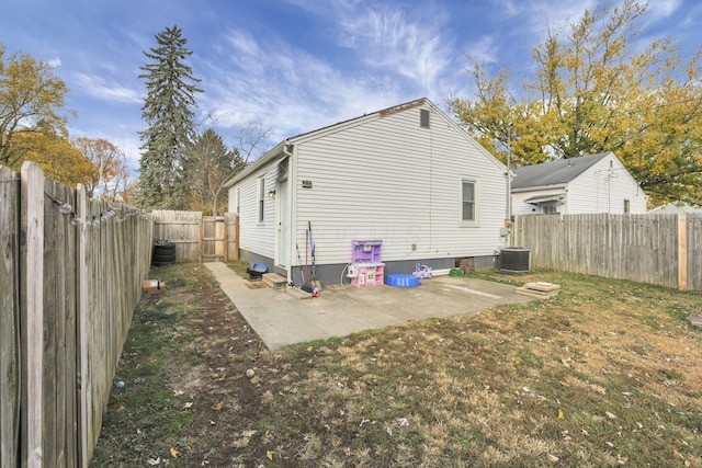 rear view of property with a lawn, central AC unit, and a patio