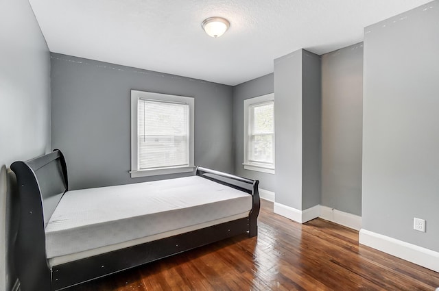 bedroom with dark wood-type flooring